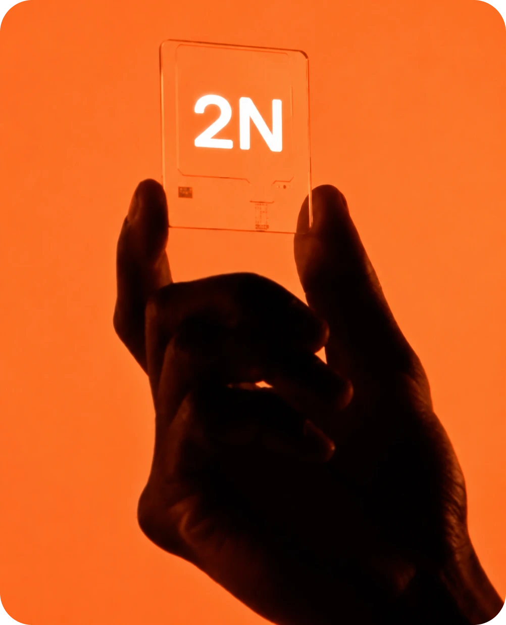 Hand holding a transparent 2N SIM card against an orange background